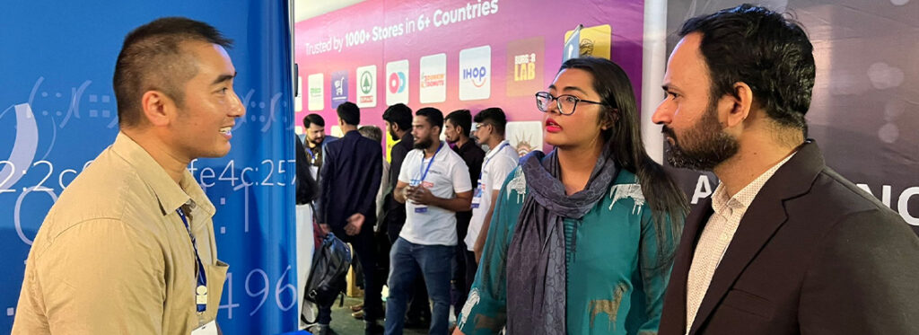 Tuan Nguyen (left) meeting with visitors at the APNIC booth.