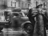 A policeman directs traffic on the corner of Queen and William Street, Brisbane, during very inclement weather, December 19, 1954.
